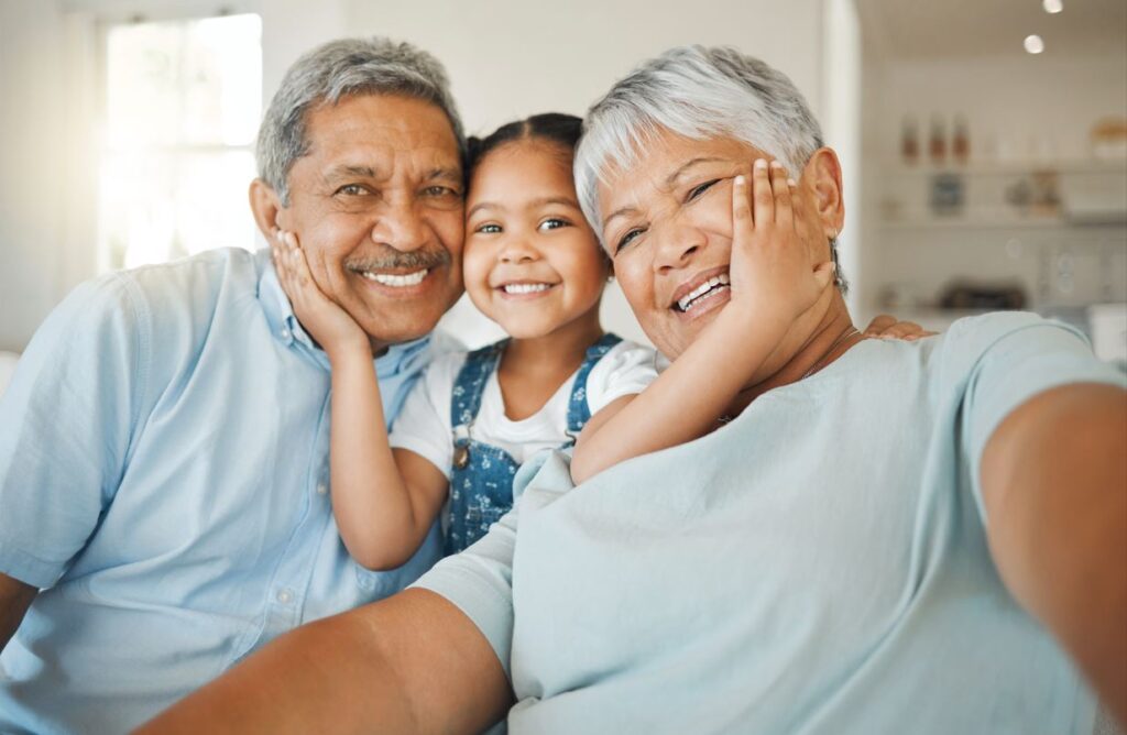 older couple smiling with granddaughter