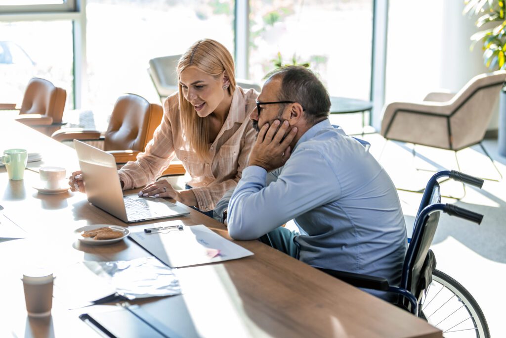 Businessman in a wheelchair talking to his female colleague